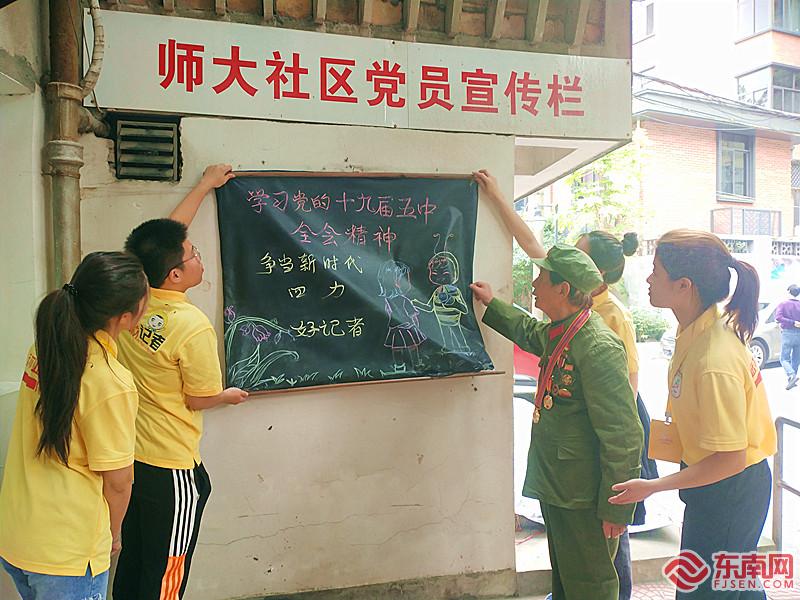 黄以孟老党员与同学们在社区挂出黑板报 东南网记者张立庆摄.jpg