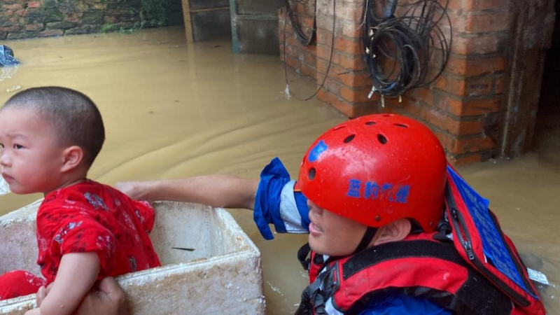 尤剑锋救助在洪灾中的儿童。受访者供图.png
