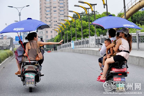 违规加装遮阳伞的电动车，易翻车还危及行人安全（资料图）