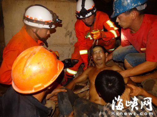 受伤工人痛得紧咬牙关，额头满是豆大的汗珠，救援人员准备将钢筋靠地面的一头剪断