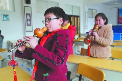 渭田中心小学的孩子们在练习吹奏葫芦丝.