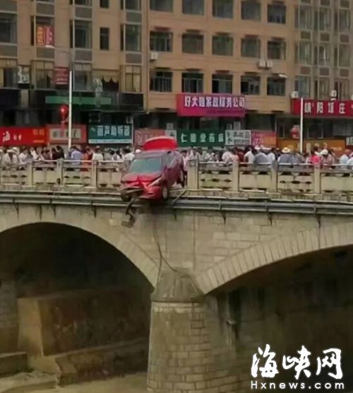 红色小车冲出护栏后，半个车身悬在十几米高的桥外（网友供图）