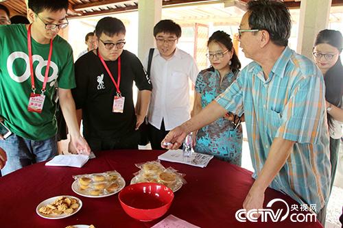 厦门市闽南文化研究会会长陈耕向采访团成员介绍博饼游戏。
