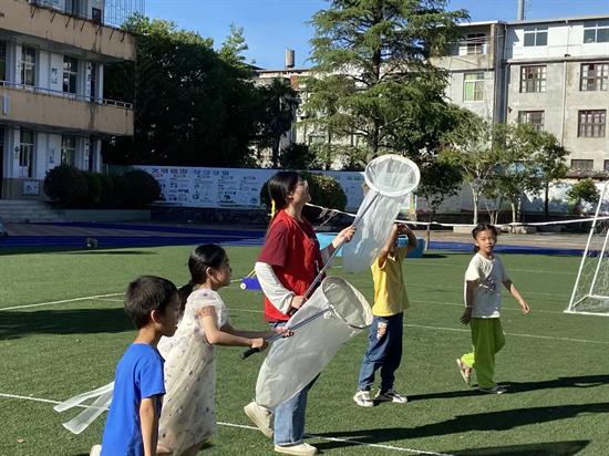 志愿队员们带着夏令营孩子们在大湖中心小学的菜园与操场上捕捉昆虫 福建农林大学供图.png