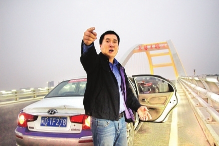 朱江涛在五缘大桥上给记者讲述当时救人的经过