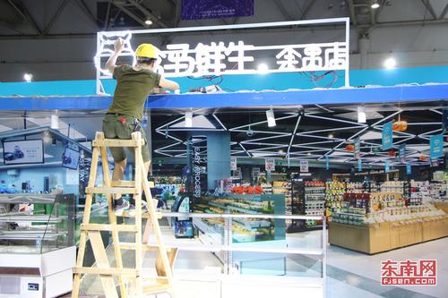 1526480947121039774.jpg 盒马鲜生展区的员工正在进行最后的装饰.jpg