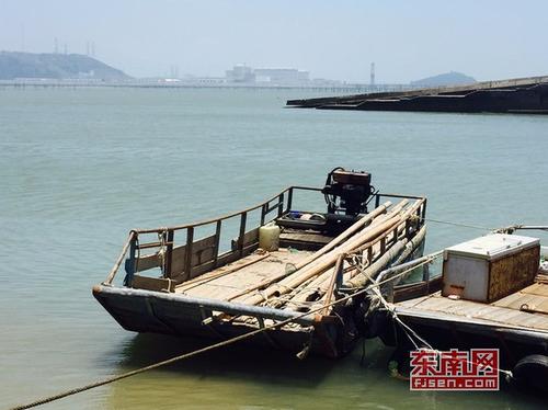 1530176948484083334.jpg 在渔井码头旁,村民扣押一艘三合公司雇佣的泡沫运输船漂浮竹竿船只。陈翊群摄.jpg