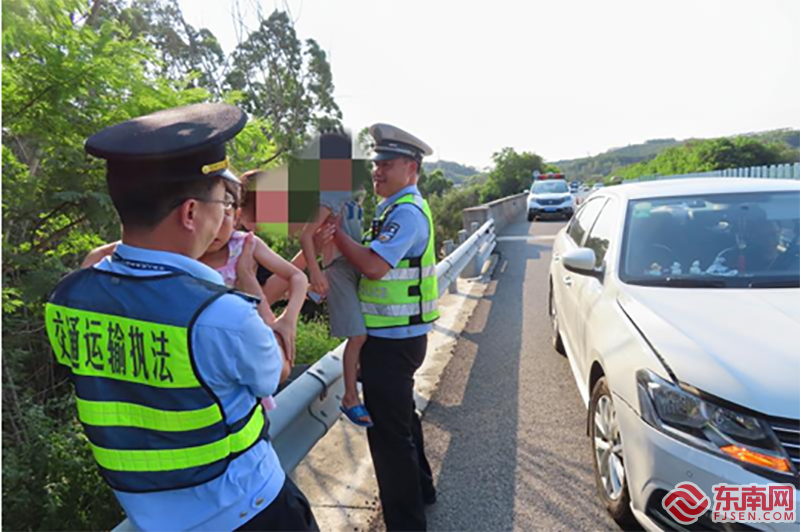 执法人员安慰事故现场的两名小孩。省交通保障中心 供图.png