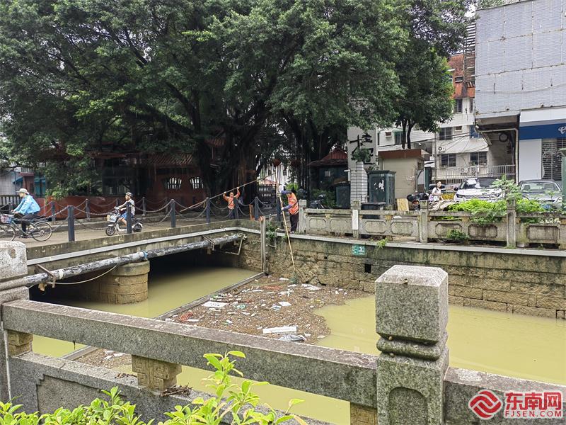 7日上午，铜盘河边，环卫工人清理暴雨后的河面垃圾。.jpg