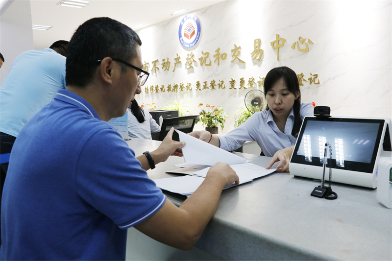在福州市不动产登记和交易中心服务窗口，登记人员正在和办理业务的群众进行交流。 东南网记者郑晓丹摄.jpg