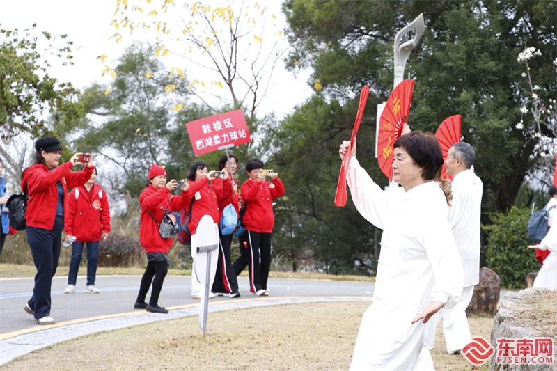 步道上,有太极扇爱好者进行锻炼,吸引了健步走参与者驻足拍照 东南网记者颜财斌 摄.jpg